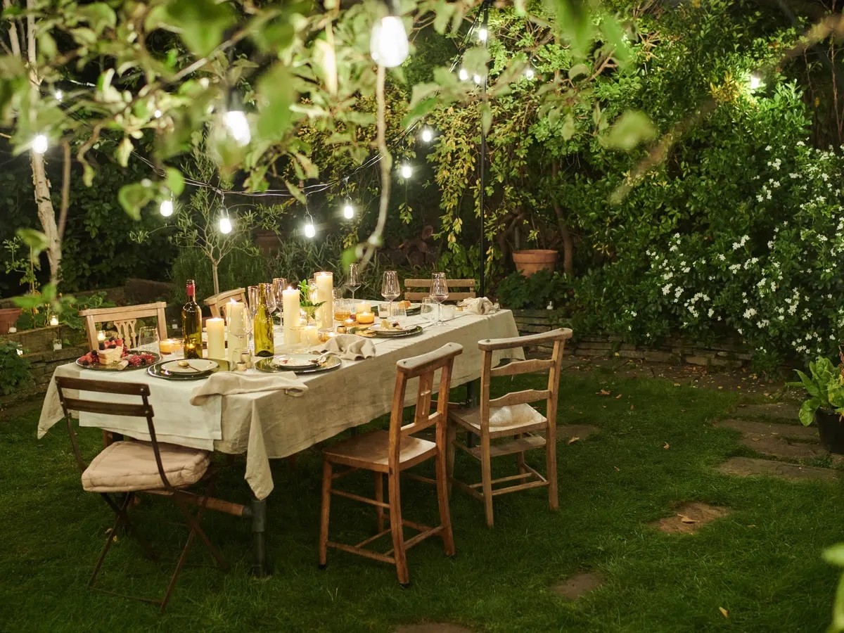 Al fresco garden dining table under string lights